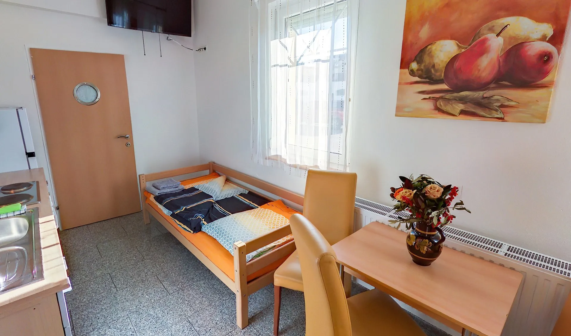 Einzelzimmer mit Küchenzeile, Esstisch und TV
